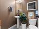 Stylish powder room featuring modern fixtures, a pedestal sink, elegant decor, and a neutral color palette at 7476 Opal Star St, North Las Vegas, NV 89084