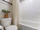 Bright bathroom featuring a shower with white tiled walls, toilet, and minimalist decor, creating a clean, modern look at 7476 Opal Star St, North Las Vegas, NV 89084