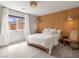 Bright bedroom features a wood-paneled headboard, neutral colors and natural light from the window at 7476 Opal Star St, North Las Vegas, NV 89084