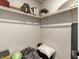 Neutral walk-in closet featuring shelving, packed with assorted storage boxes, bags, and items, maximizing organization at 7476 Opal Star St, North Las Vegas, NV 89084