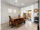 Bright dining area with a wooden table and bench, sliding glass doors to patio, and modern wall decor at 7476 Opal Star St, North Las Vegas, NV 89084