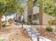 A modern townhouse with neutral stucco, features a stairway entrance and desert landscaping that adds curb appeal at 7476 Opal Star St, North Las Vegas, NV 89084