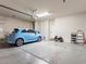 Open garage space with epoxy flooring, a light blue car, and storage shelves, blending functionality at 7476 Opal Star St, North Las Vegas, NV 89084