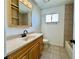 Bathroom featuring tub with tile surround, laminate countertop and wood cabinets at 8072 Hackberry Dr, Las Vegas, NV 89123