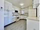 Compact kitchen featuring white appliances and laminate flooring at 8072 Hackberry Dr, Las Vegas, NV 89123