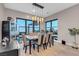 Dining room with elegant chandelier, floor-to-ceiling windows, and neutral furnishings at 818 Laceleaf St, Las Vegas, NV 89138