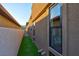 Modern home exterior with an artificial lawn, large windows, and a well-maintained landscape at 818 Laceleaf St, Las Vegas, NV 89138