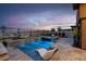 Modern pool area with waterfall features, outdoor lounge furniture and desert landscape views at 818 Laceleaf St, Las Vegas, NV 89138