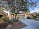 Two-story home with a two-car garage, desert landscaping, and a covered entryway at 8205 Celina Hills St, Las Vegas, NV 89131