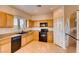 Well-appointed kitchen with wood cabinetry, granite countertops, and black appliances under recessed lighting at 8205 Celina Hills St, Las Vegas, NV 89131