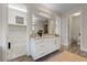 Bright bathroom featuring double sinks, a large mirror, and a seamless transition to the walk-in closet at 845 Loch Katrine Ave, Henderson, NV 89012