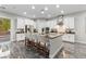 Bright kitchen with stainless steel appliances, oversized island with seating, and glass door to the backyard at 845 Loch Katrine Ave, Henderson, NV 89012