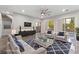 Comfortable living room featuring a modern sofa, stylish chairs, sleek TV console, and a ceiling fan at 845 Loch Katrine Ave, Henderson, NV 89012