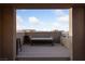 Framed view of an outdoor living space with a bench, two stools and views of the community in the distance at 845 Loch Katrine Ave, Henderson, NV 89012