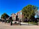 Beautiful brick home with lush landscaping, wrought iron fencing and gated entry, set against a clear blue sky at 8690 W Ford Ave, Las Vegas, NV 89148