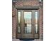 Elegant front door with decorative glass panels and sidelights framed by brick facade and sconce lighting at 8690 W Ford Ave, Las Vegas, NV 89148