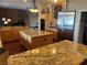 Open kitchen featuring granite countertops, double islands, stainless steel appliances, and brick fireplace at 8690 W Ford Ave, Las Vegas, NV 89148