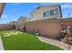 Backyard with artificial grass, decorative rock, potted plants and brick wall at 9113 Sea Mink Ave, Las Vegas, NV 89149