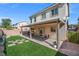 Home's backyard features artificial turf, covered patio, and brick pavers at 9113 Sea Mink Ave, Las Vegas, NV 89149