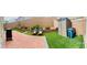Landscaped backyard featuring artificial grass, a brick patio, and retaining walls at 10077 Cooper Mountain St, Las Vegas, NV 89141
