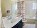 Clean bathroom with a shower/tub, floral shower curtain and vanity with a marble countertop at 10077 Cooper Mountain St, Las Vegas, NV 89141