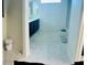 A bathroom featuring dark cabinets, white walls, and gray tile flooring at 10077 Cooper Mountain St, Las Vegas, NV 89141