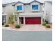 Charming two-story home with a red garage door and low maintenance landscaping at 10077 Cooper Mountain St, Las Vegas, NV 89141