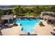 Aerial view of a sparkling community pool with multiple seating areas and lush landscaping in a residential community at 10809 Garden Mist Dr # 2050, Las Vegas, NV 89135