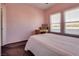 Bright bedroom with pink walls featuring two windows and a desk, filled with natural light at 10809 Garden Mist Dr # 2050, Las Vegas, NV 89135