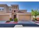 Charming townhome featuring a stone accent wall, well-kept landscaping, and two-car garage at 10809 Garden Mist Dr # 2050, Las Vegas, NV 89135