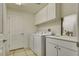 Well-equipped laundry room with white cabinetry and appliances, plus a utility sink at 10809 Garden Mist Dr # 2050, Las Vegas, NV 89135