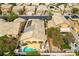 An aerial view shows houses with backyard pools, solar panels, and desert landscaping at 115 Cora Hills Ct, Las Vegas, NV 89148