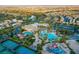 An aerial view showcases community features: pools, tennis, basketball, lush landscaping, and waterways at 115 Cora Hills Ct, Las Vegas, NV 89148