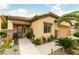 Inviting single-story home with lush landscaping and a covered entry and a well maintained lawn at 115 Cora Hills Ct, Las Vegas, NV 89148