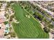 Aerial view of a lush golf course featuring manicured greens, sand traps, and a residential community in the background at 115 Cora Hills Ct, Las Vegas, NV 89148