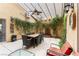 Covered patio and outdoor dining area with decorative wall fountain and lush greenery at 115 Cora Hills Ct, Las Vegas, NV 89148