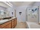 Bathroom with double vanity, framed mirrors, and a combined bathtub and shower with glass doors at 1152 Pine Cove Ct, Henderson, NV 89011