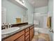 Bathroom featuring a granite-topped vanity and shower-tub combo with sliding glass door at 1152 Pine Cove Ct, Henderson, NV 89011