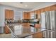 Modern kitchen boasts stainless steel appliances, including a large refrigerator, and an island with a granite countertop at 1152 Pine Cove Ct, Henderson, NV 89011