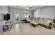 Spacious living room with gray walls, tile flooring, a comfortable sectional sofa, and bright natural light at 1152 Pine Cove Ct, Henderson, NV 89011