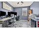 Office space with dark walls, wood-look floors, and a large desk setup for work at 1152 Pine Cove Ct, Henderson, NV 89011