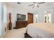 Neutral-toned main bedroom with ceiling fan, dresser and large picture window at 11540 Snow Creek Ave, Las Vegas, NV 89135