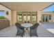 This covered patio offers outdoor living space with a dining table and access to the backyard at 11540 Snow Creek Ave, Las Vegas, NV 89135