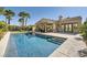 This backyard features a sparkling pool, covered patio, and manicured landscaping for relaxation at 11540 Snow Creek Ave, Las Vegas, NV 89135