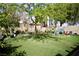 Lush backyard with artificial grass, mature trees, and patio seating, offering a serene and low-maintenance outdoor space at 1912 E Pyle Ave, Las Vegas, NV 89183