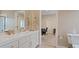 Bathroom with double sinks, white cabinetry and a view of the adjacent office area at 2355 Villandry Ct, Henderson, NV 89074