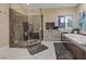 Bright bathroom with a soaking tub, glass shower, and artistic stained glass window at 2355 Villandry Ct, Henderson, NV 89074