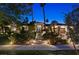 Night view of an elegant home with lush landscaping, palm trees, and a walkway leading to the front entrance at 2355 Villandry Ct, Henderson, NV 89074