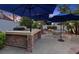 Relaxing backyard with a stone outdoor kitchen, dining area, fire pit, and lush landscaping at 2355 Villandry Ct, Henderson, NV 89074