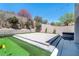 A backyard featuring a putting green, hot tub, large patio, string lights and brick wall at 257 Elder View Dr, Las Vegas, NV 89138